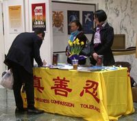 0c8d6694dd85c44d70fbd8254aebf40f A visitor signs a petition to support Falun Gong.