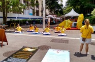 Practitioners demonstrate the meditation exercise in Sao Paulo and reach out to the public to increase awareness of the persecution of Falun Dafa in China