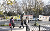 Chinese tourists reading the materials on Falun Gong's display boards