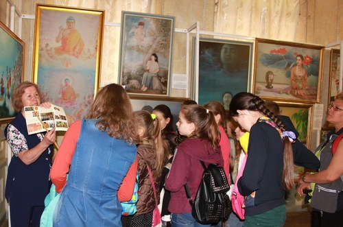 55e5cacf92e0cb15b59687cbde3a17b9 An exhibition guide introduces the artwork to visitors.