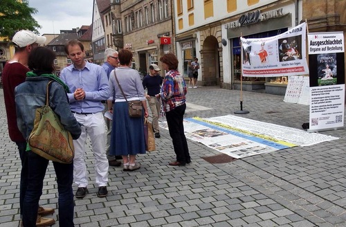 Local residents and tourists learn about Falun Dafa on June 4, 2016.