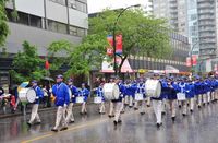 The Divine Land Marching Band leads the Falun Dafa practitioners in a pouring rain during the 45th annual Hyack International Parade in New Westminster.