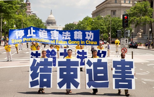 Five practitioners hold large Chinese characters reading “Falun Dafa is Good.”