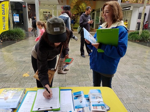 Passersby sign a petition calling for an end to organ harvesting.
