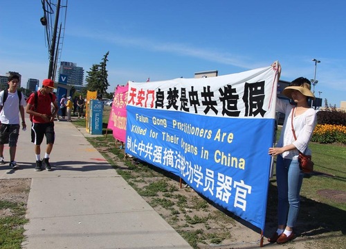 9f83b720dc534b2852bf4ba81c7ded6f Falun Gong practitioners hold banners to draw public attention to the persecution in China.