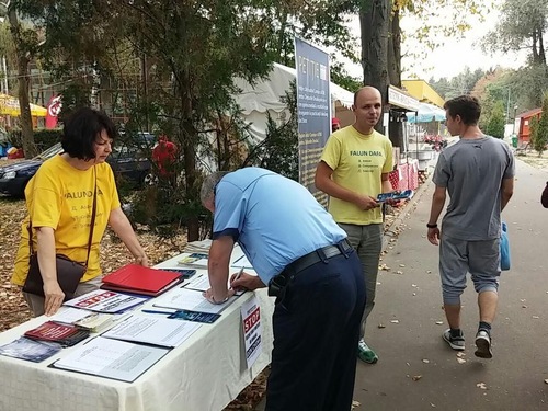 Police officer signs the petition to support the lawsuits filed against Jiang Zemin, the former Chinese leader who banned Falun Dafa in 1999.