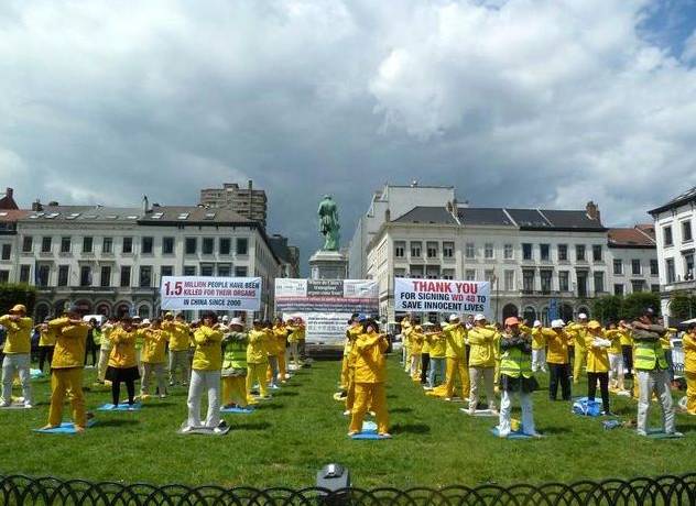 Falun Gong practitioners exercise in a group outside of the European Parliament complex in Brussels.
