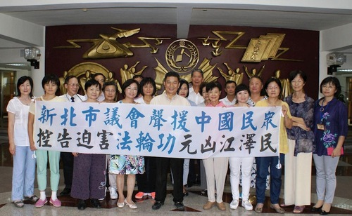 Group photo of New Taipei City Council. The banner reads, “New Taipei City Council supports Chinese citizens' suing Jiang Zemin, the perpetrator of the persecution of Falun Gong.”