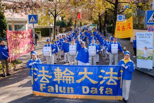 Falun Gong practitioners conduct activities including performance by the Tian Guo Marching Band in front of the Chinese Consulate in Munich.