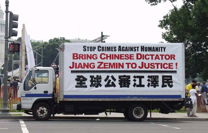 A Truck Covered in Large Posters About "Bringing Jiang to Justice" Slowly Travels the Streets of the Washington DC, USA.