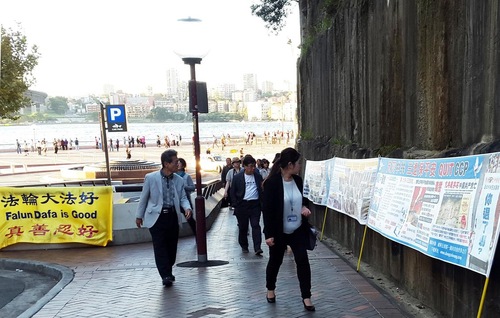 Chinese tourists see posters about Falun Gong near the Sydney Opera House in Sydney, Australia.