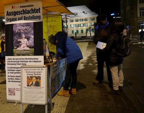 f9198b66327f2ce2e23fdc804b42ad4b Passers-by sign a petition against the CCP's live organ harvesting of prisoners of conscience.