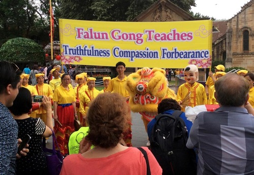 9e985e5c8927b04385e545dd12114e65 Falun Gong practitioners pose for photos at Centenary Square before the start of Chinese New Year celebrations.