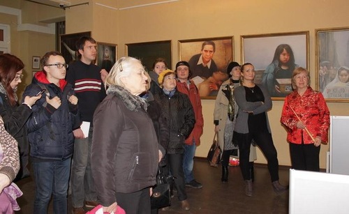 Visitors view the artworks and learn the stories behind the paintings.