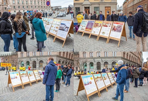 Passersby stop to read Falun Gong display boards.