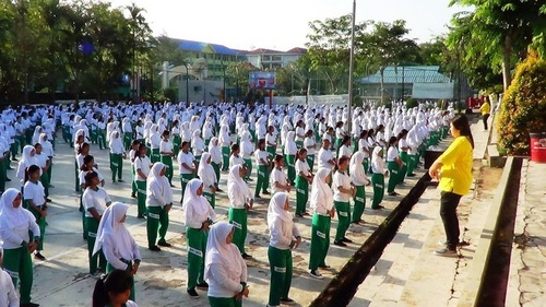 0f64f09389c0d0b2f7fb708ff1fa3514 Teachers and students at Kartini High School learn the Falun Gong exercises.