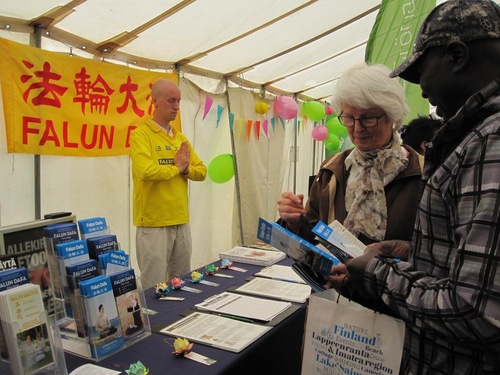 Many people sign a petition to show support for Falun Gong during the World Village Festival in Helsinki, Finland.