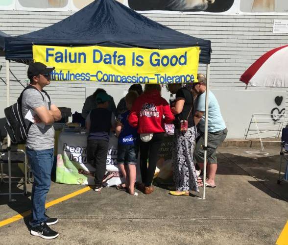 Corrimal Spring in Corimal festival visitors learning how the make a lotus flower using origami paper.