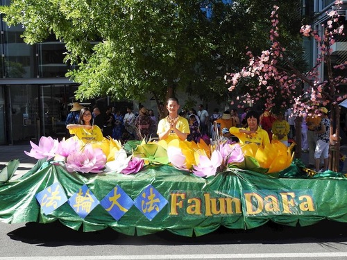 a5c3682eccb9d14c0af339d2a7d954ad Practitioners demonstrate the Falun Dafa exercises on the float decorated with lotus and plum flowers.