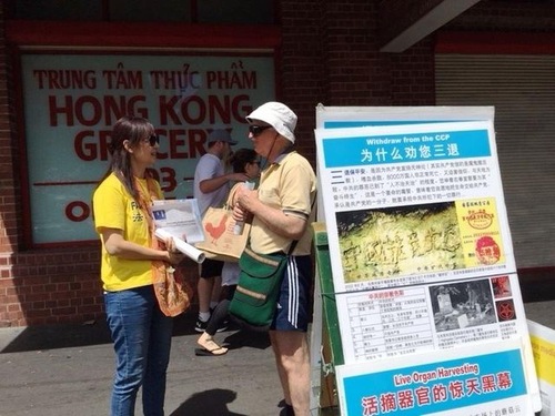 0c7cbd4e9cba66317a6385aba2538dbe Passersby talk with practitioners about Falun Dafa.