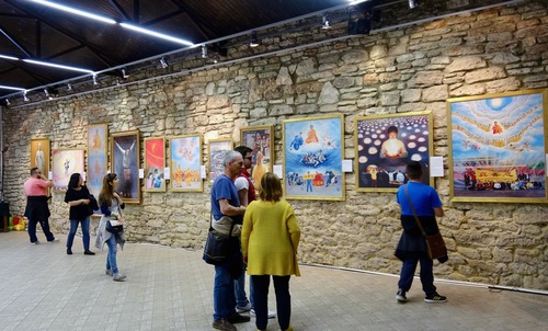 Visitors contemplate the exhibit’s paintings.