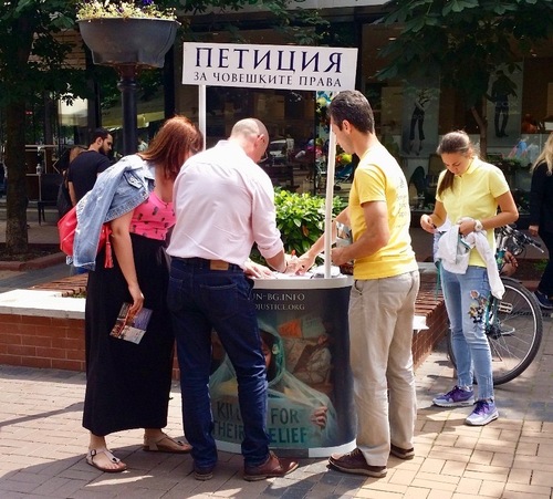 Visitors at the May 24 celebrations visiting the Falun Dafa stand and also signing the petition to end the persecution of Falun Dafa in China.