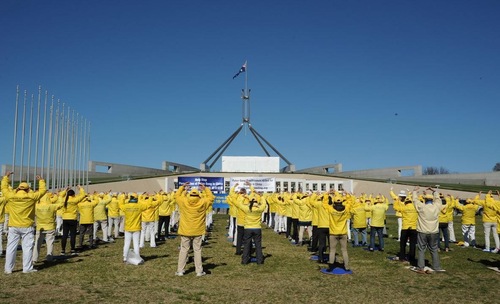 901fea6cf6f2039f47db798f7d6048e7 Falun Gong practitioners do the exercises together in front of the Australian Parliament.