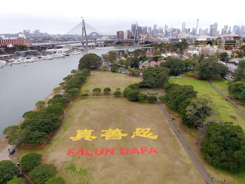 bc6c89d65859c3b756ba3baa80db8030 Falun Gong practitioners arranged themselves in the Chinese characters for “Truthfulness-Compassion-Forbearance” and the English words “Falun Dafa” in Jubilee Park near Darling Harbour in Sydney, Australia, on September 8, 2018.
