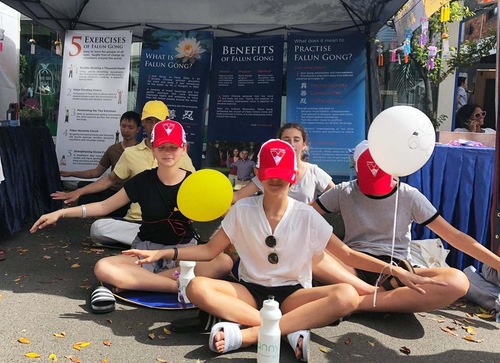 Visitors at the street festival learn the Falun Gong meditation.