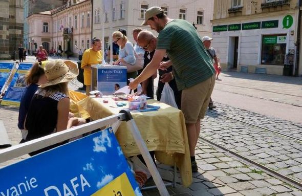 Visitors at the Falun Dafa table in Banská Bystrica, Slovakia.