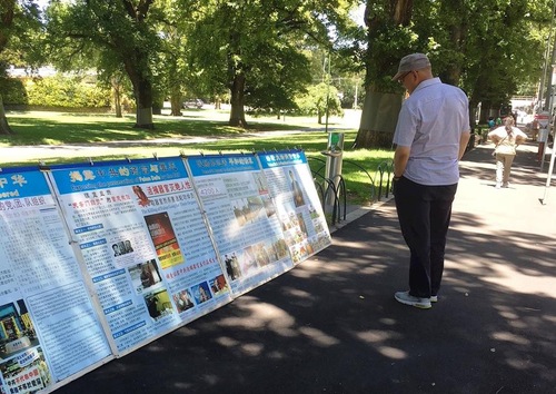 2c825ff83de86e25c9c4b7b75fe59884 Passersby read informational posters about Falun Gong at Fitzroy Gardens in Melbourne.