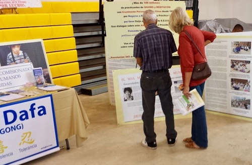 Passerby at the Vegan Festival visiting the Falun dafa stand reading the information boards.