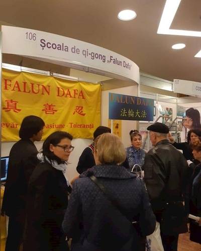 Visitors at the Falun Gong booth talk with practitioners.
