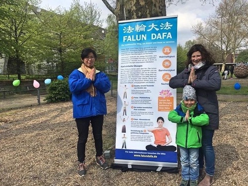 A woman (first on right) and her son have their photo taken with a Falun Gong practitioner.