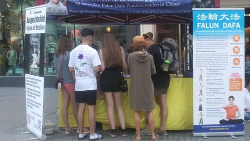 46a4faa7c94477a75f47e635088bcf75 Passersby sign the petition against the persecution.