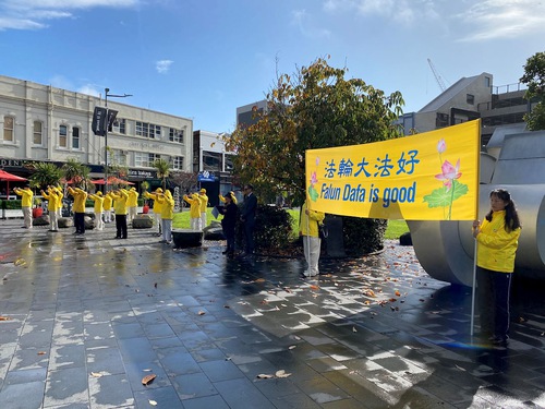 Falun Gong practitioners practice the exercises in front of the New Market business centre.