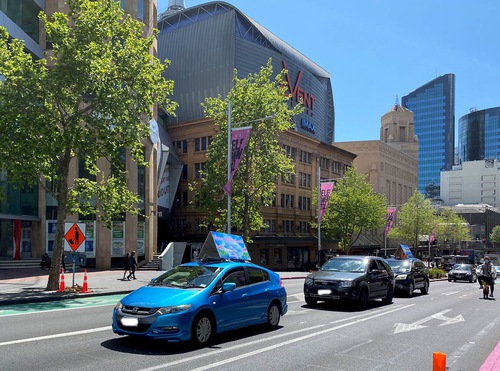 4cc16c638b554e6d921e45742c39c950 The car parade passes through downtown Auckland.