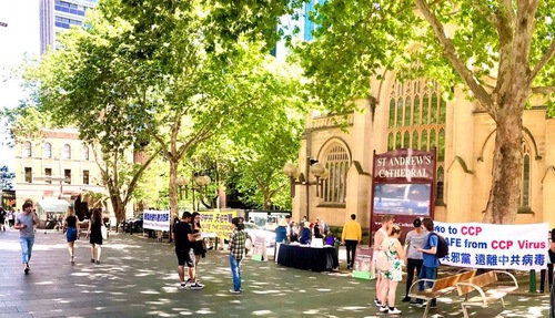 38d7e1570dd4c6100f00f4cd6f5d35c7 Passersby reading banners at the “End the CCP” event in Sydney
