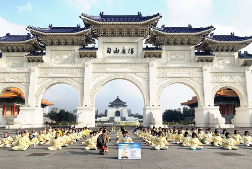 The peaceful atmosphere and energy of practitioners doing the exercises in front of Liberty Square in Taipei attracted the attention of overseas visitors. Several people stopped to take photos.
