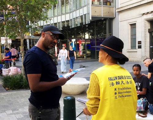 169fb6dd4d69ff06a4c69a25229a6f56 Practitioners talk to passersby about Falun Dafa.
