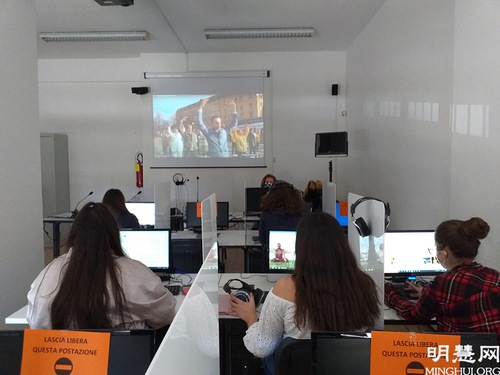 668fd3e5b51c022e628e32973403d142 Students watching a film introducing Falun Dafa's teachings.