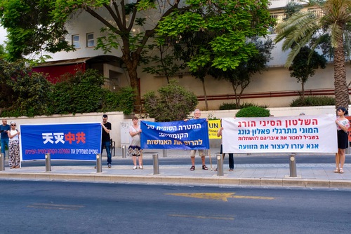 c4b030dbba1a011104e5423ed72ac94d Practitioners holding banners in front of the Chinese Embassy in Tel Aviv.