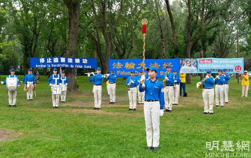 The Tian Guo Marching Band gives a performance and Falun Dafa practitioners demonstrate the exercises in Saint-Jean-sur-Richilieu on August 7, 2021 during activities to raise awareness of the persecution in China.