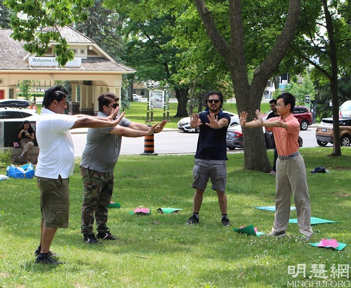 Tourists learn the exercises at the Falun Dafa practice site in Niagara Falls.