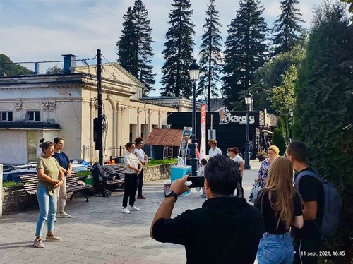 0d585baa1a455982d3fe463565c2c5f7 A member of the public takes a photo of the group of practitioners doing the Falun Dafa exercises at the information event in Sinaia.