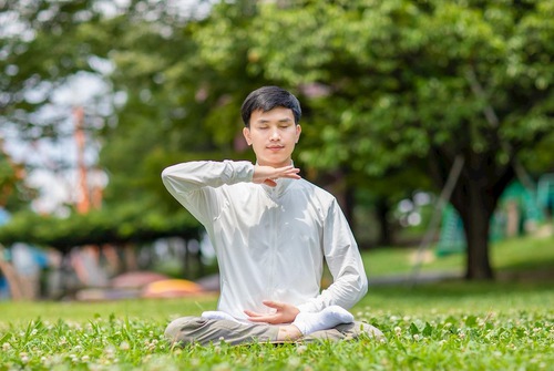 Youwei Ruan does the fifth Falun Dafa exercise, a sitting meditation.