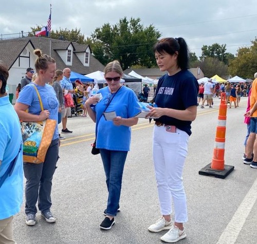 428857282e9315ed990260c4271c92cc People learn about Falun Dafa at the Aubrey Peanut Festival on October 2.