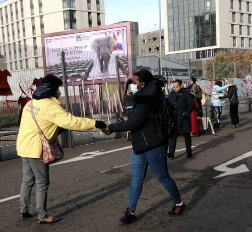 Practitioners hand out information outside the COP26 conference.