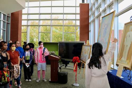 Chloe Phong, president of the Falun Dafa Club at GGC, begins a guided tour introducing the first theme of the exhibition, the “Arrival of the Lord Buddha.”