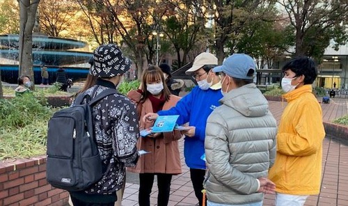 Passersby talked to Falun Gong practitioners about the persecution in China.